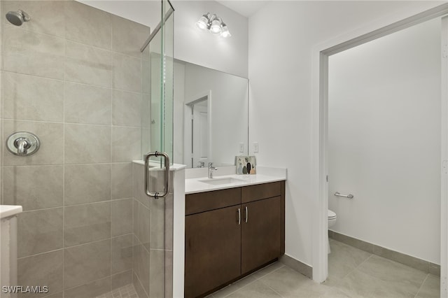 bathroom featuring tile patterned floors, vanity, an enclosed shower, and toilet