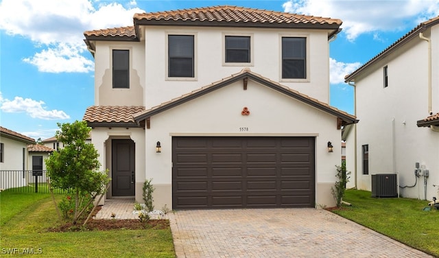 mediterranean / spanish-style home featuring a garage, central AC, and a front lawn