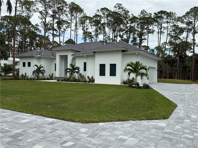 view of front of property with a front yard and a garage