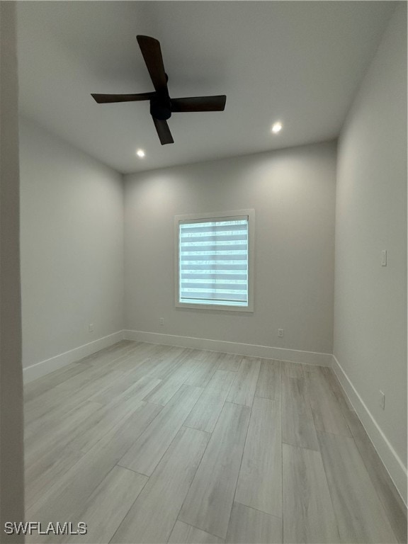 empty room with ceiling fan and light hardwood / wood-style flooring