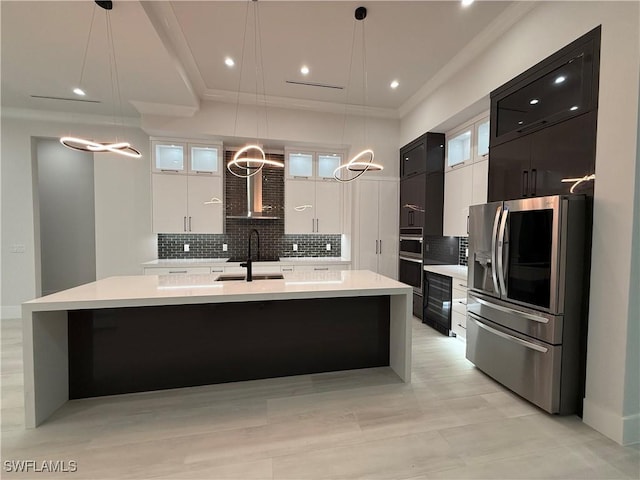 788 9th St SW, Naples, FL 34117 - kitchen featuring stainless steel appliances, light countertops, a large island with sink, tasteful backsplash, and hanging light fixtures