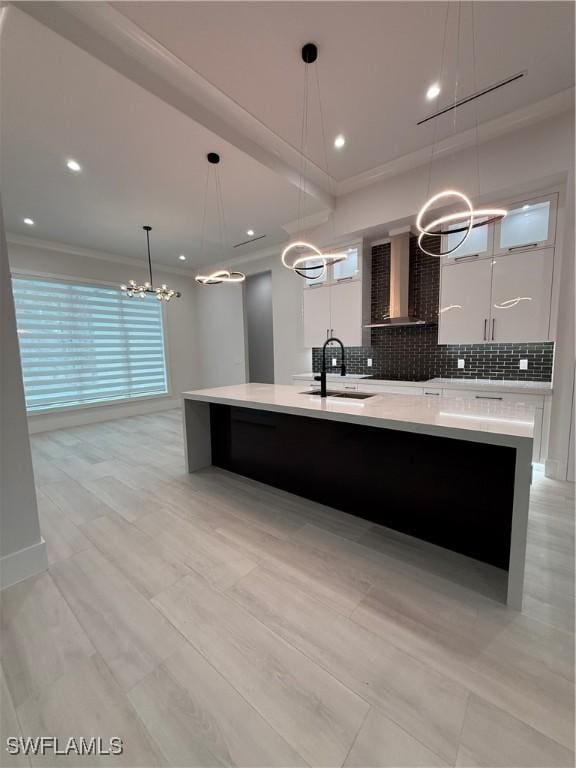 788 9th St SW, Naples, FL 34117 - kitchen featuring wall chimney exhaust hood, a chandelier, crown molding, modern cabinets, and light countertops