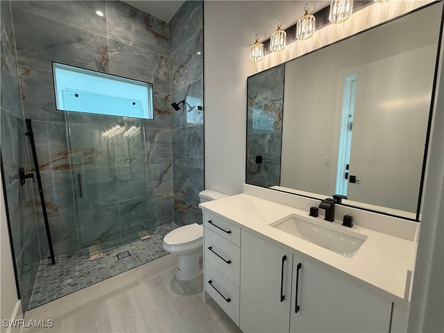 bathroom with tile patterned floors, vanity, toilet, and tiled shower