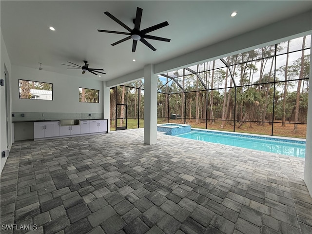 view of swimming pool featuring a lanai, exterior kitchen, an in ground hot tub, and a patio