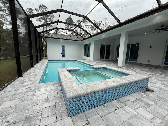 view of pool with an in ground hot tub, a patio, ceiling fan, and a lanai