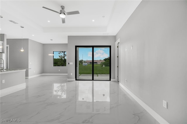 unfurnished room with ceiling fan, a raised ceiling, and light tile patterned floors