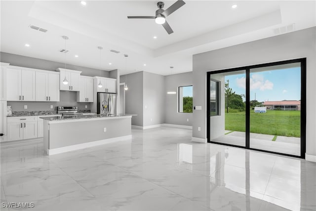 kitchen featuring light tile patterned flooring, a tray ceiling, and stainless steel fridge