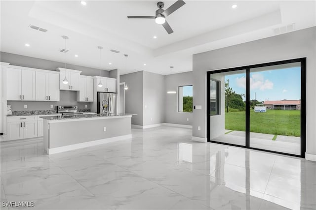 1220 Edison Ave, Lehigh Acres, FL 33972 - kitchen featuring visible vents, a kitchen island with sink, a tray ceiling, stainless steel appliances, and baseboards