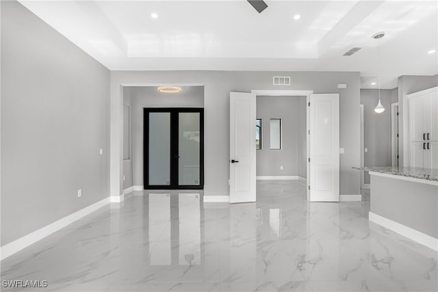 unfurnished room featuring light tile patterned floors, french doors, and a tray ceiling