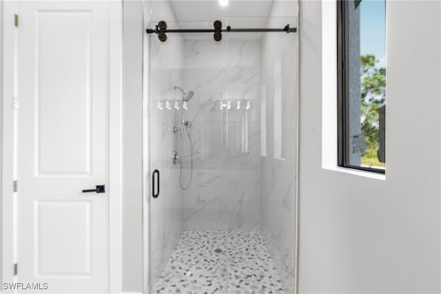 bathroom with a shower with door