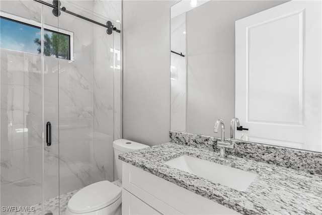 bathroom featuring a shower with shower door, vanity, and toilet