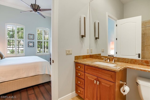 bathroom with toilet, ceiling fan, ornamental molding, hardwood / wood-style flooring, and vanity