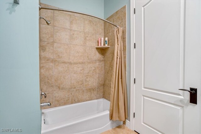 bathroom with shower / tub combo with curtain and tile patterned floors