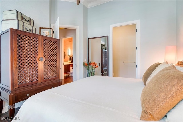 bedroom with ornamental molding, wood-type flooring, and ensuite bathroom