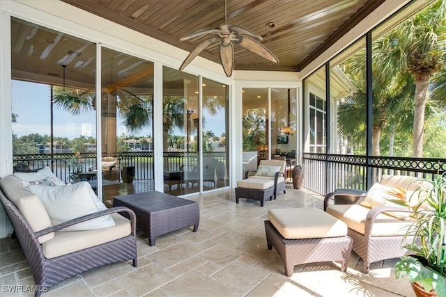 sunroom featuring ceiling fan and wooden ceiling