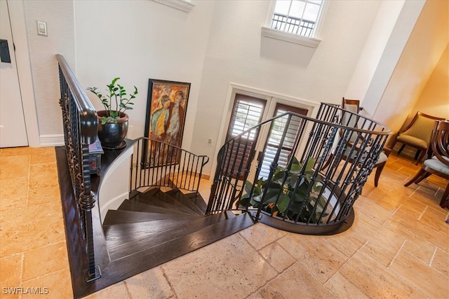 tiled entrance foyer featuring plenty of natural light and a towering ceiling