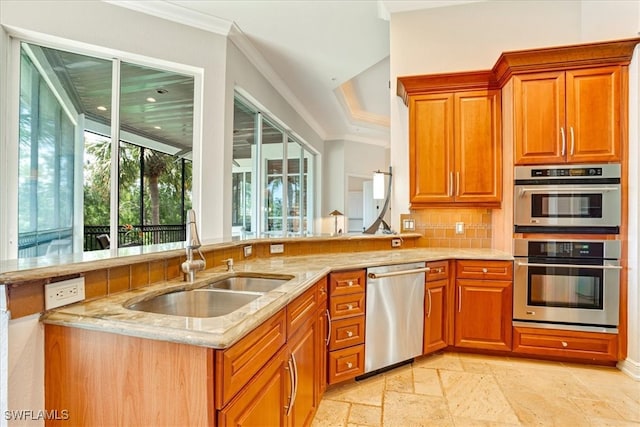 kitchen with stainless steel appliances, light tile patterned floors, light stone countertops, sink, and backsplash