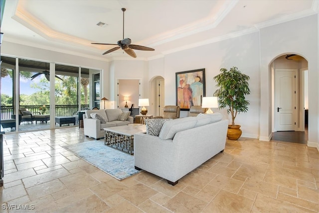 living room featuring ceiling fan, light tile patterned floors, ornamental molding, and a tray ceiling