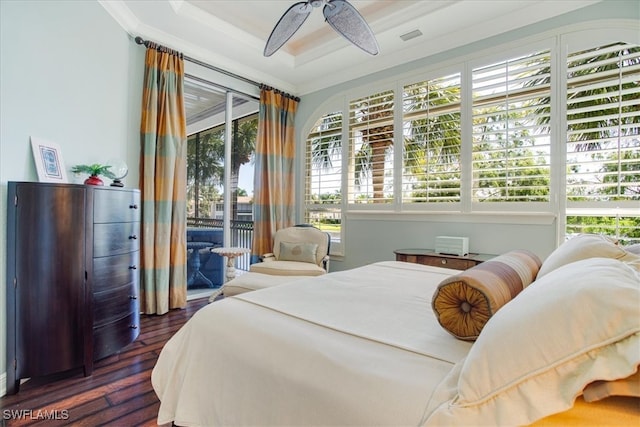 bedroom with access to exterior, dark wood-type flooring, ceiling fan, a tray ceiling, and ornamental molding