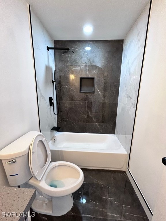 full bathroom featuring tiled shower / bath combo, vanity, and toilet