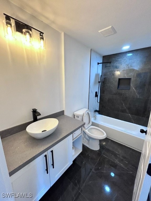 full bathroom featuring tiled shower / bath combo, vanity, and toilet