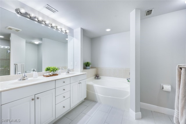 bathroom with tile patterned floors, vanity, and a bathing tub