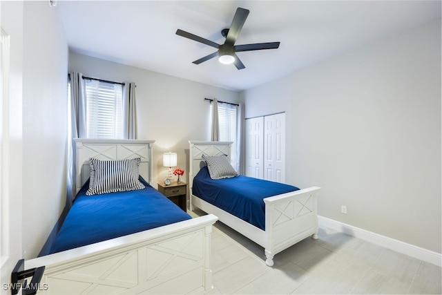 tiled bedroom with ceiling fan and a closet