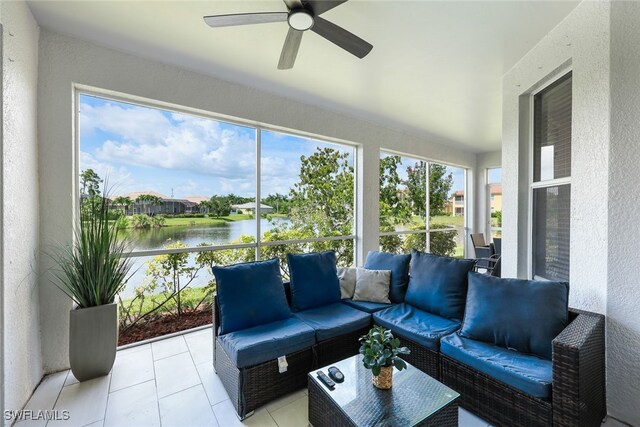 sunroom featuring ceiling fan and a water view