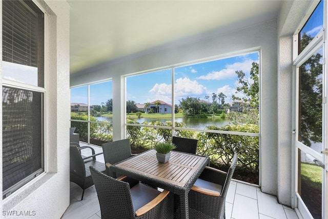 sunroom featuring a water view