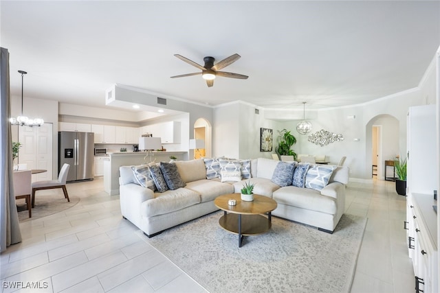 living room featuring light tile patterned flooring, ceiling fan with notable chandelier, and crown molding