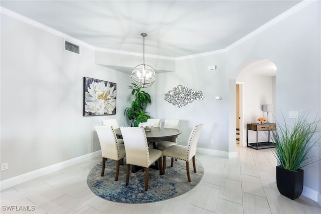 tiled dining room with ornamental molding and a chandelier