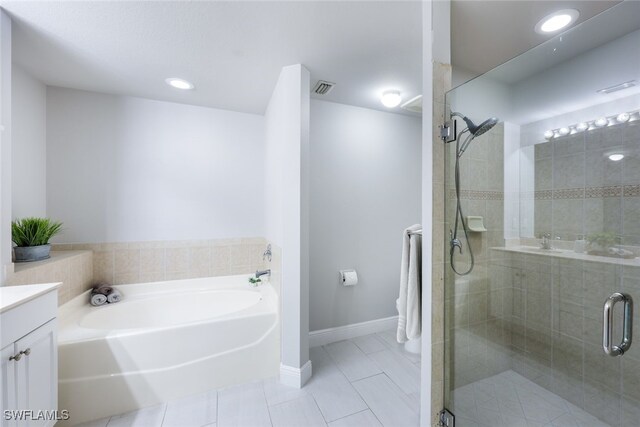 bathroom with plus walk in shower, tile patterned floors, and vanity