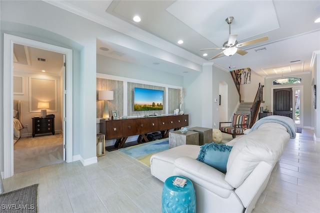 living room with ceiling fan and ornamental molding