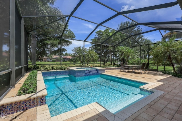 view of pool featuring a patio, glass enclosure, and an in ground hot tub