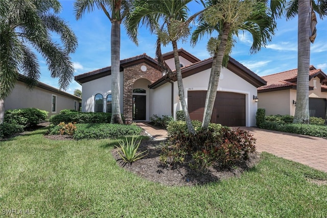 mediterranean / spanish house featuring a garage and a front yard