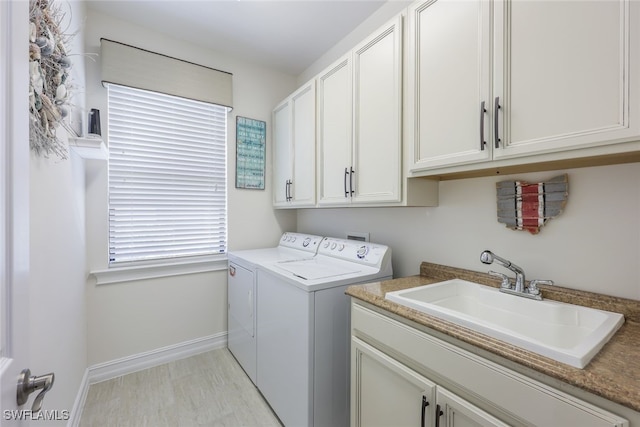 laundry area with separate washer and dryer, sink, and cabinets