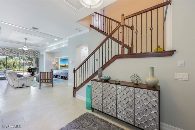 staircase featuring ornamental molding and ceiling fan