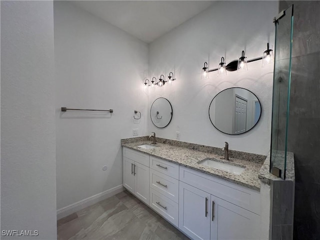 full bath featuring double vanity, baseboards, a shower with door, and a sink