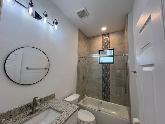 bathroom with vanity, toilet, visible vents, and combined bath / shower with glass door