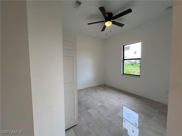 unfurnished room featuring visible vents, a ceiling fan, and baseboards