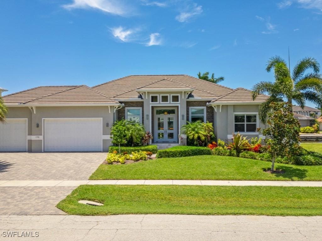 view of front of property with a garage and a front lawn