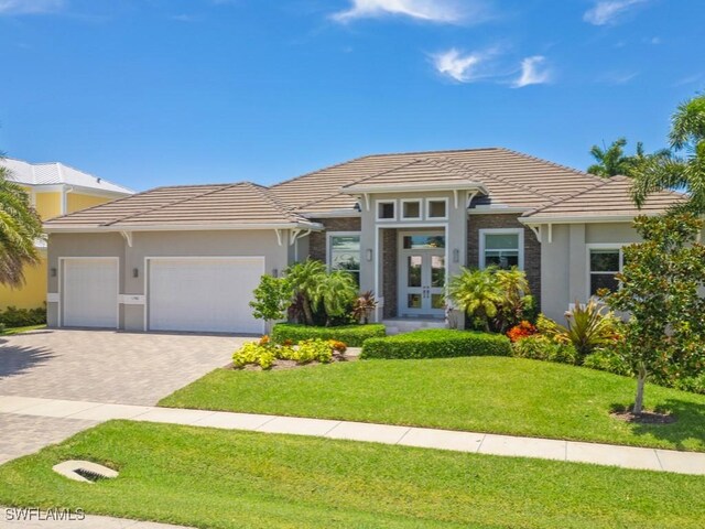 prairie-style house featuring a garage and a front yard