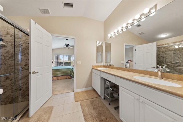 bathroom with vanity, a shower with door, tile patterned flooring, and vaulted ceiling