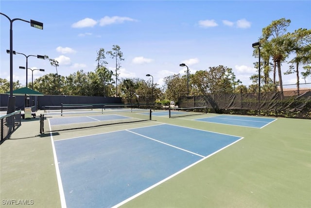 view of tennis court with community basketball court and fence