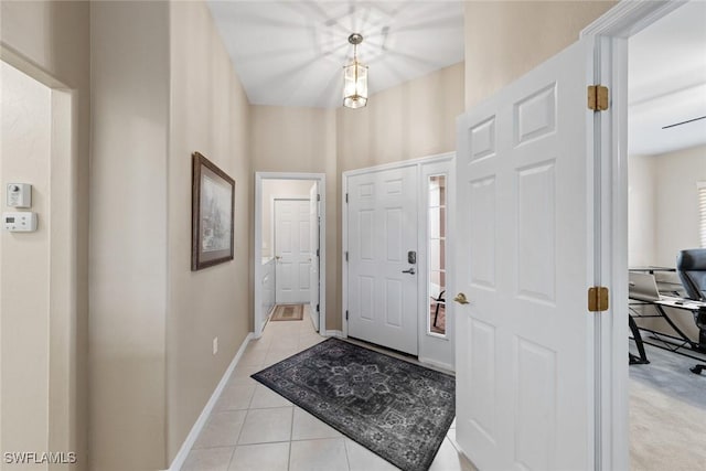 foyer entrance featuring light tile patterned flooring and baseboards