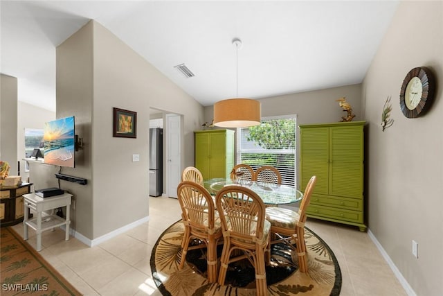 dining room featuring light tile patterned floors, visible vents, baseboards, and lofted ceiling