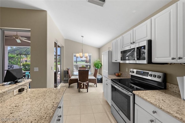 kitchen featuring vaulted ceiling, appliances with stainless steel finishes, decorative light fixtures, white cabinets, and light tile patterned floors