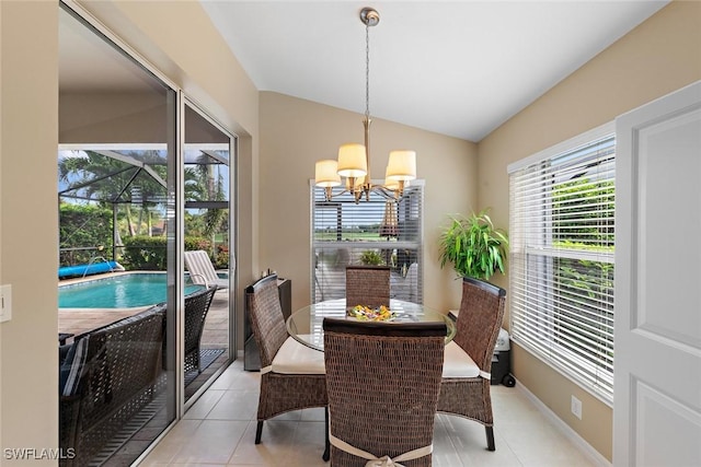 tiled dining area with vaulted ceiling and a chandelier