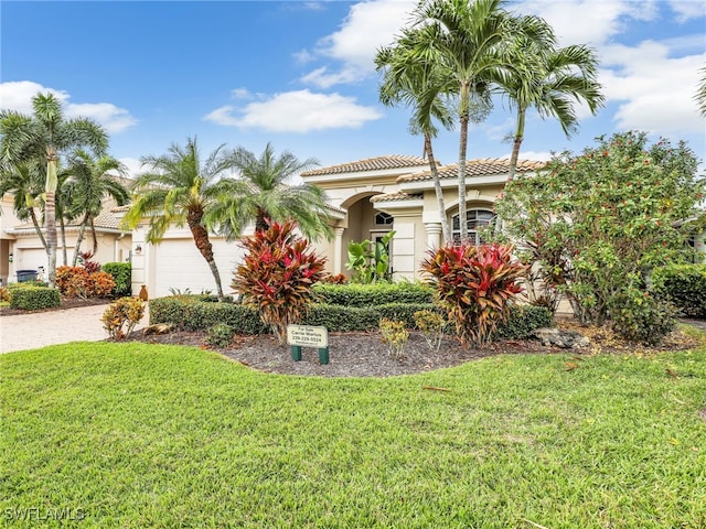 mediterranean / spanish-style house featuring a front lawn and a garage