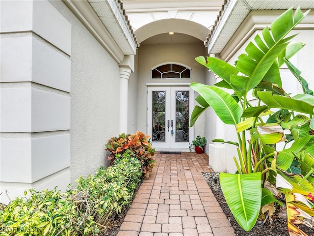 view of exterior entry featuring stucco siding and french doors